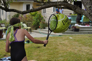 Whacking the piñata with the tennis racquet